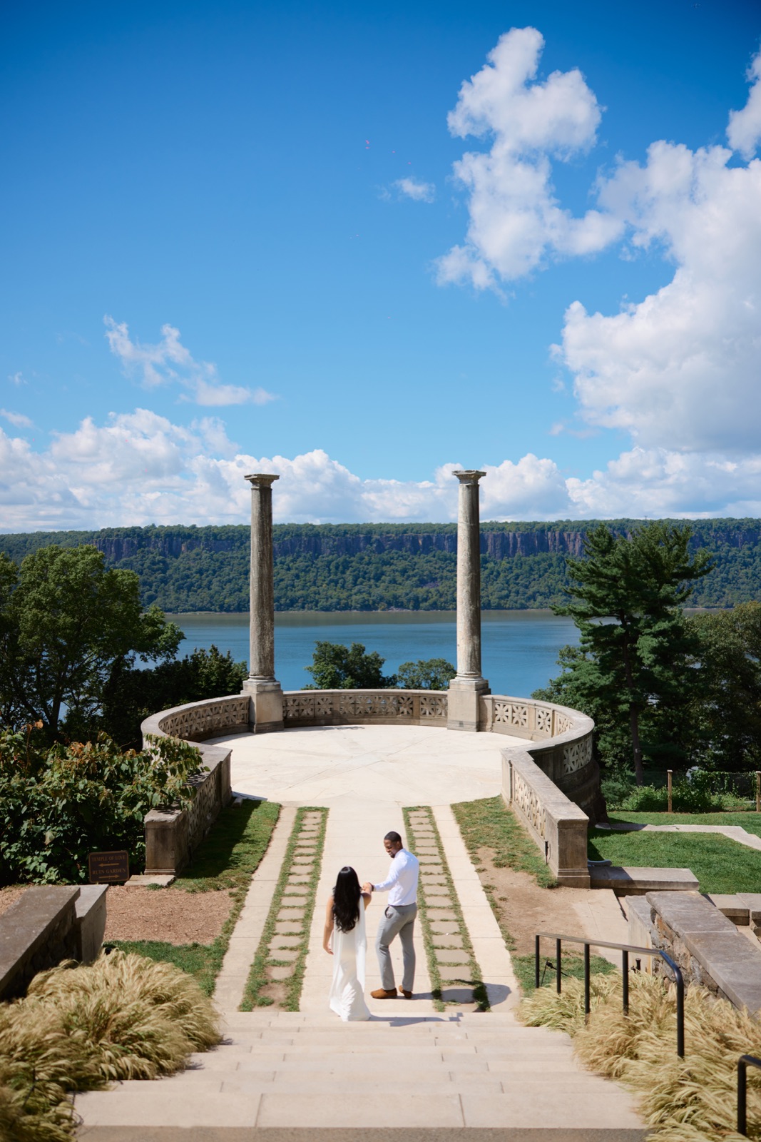 Walking toward the river overlook between two columns